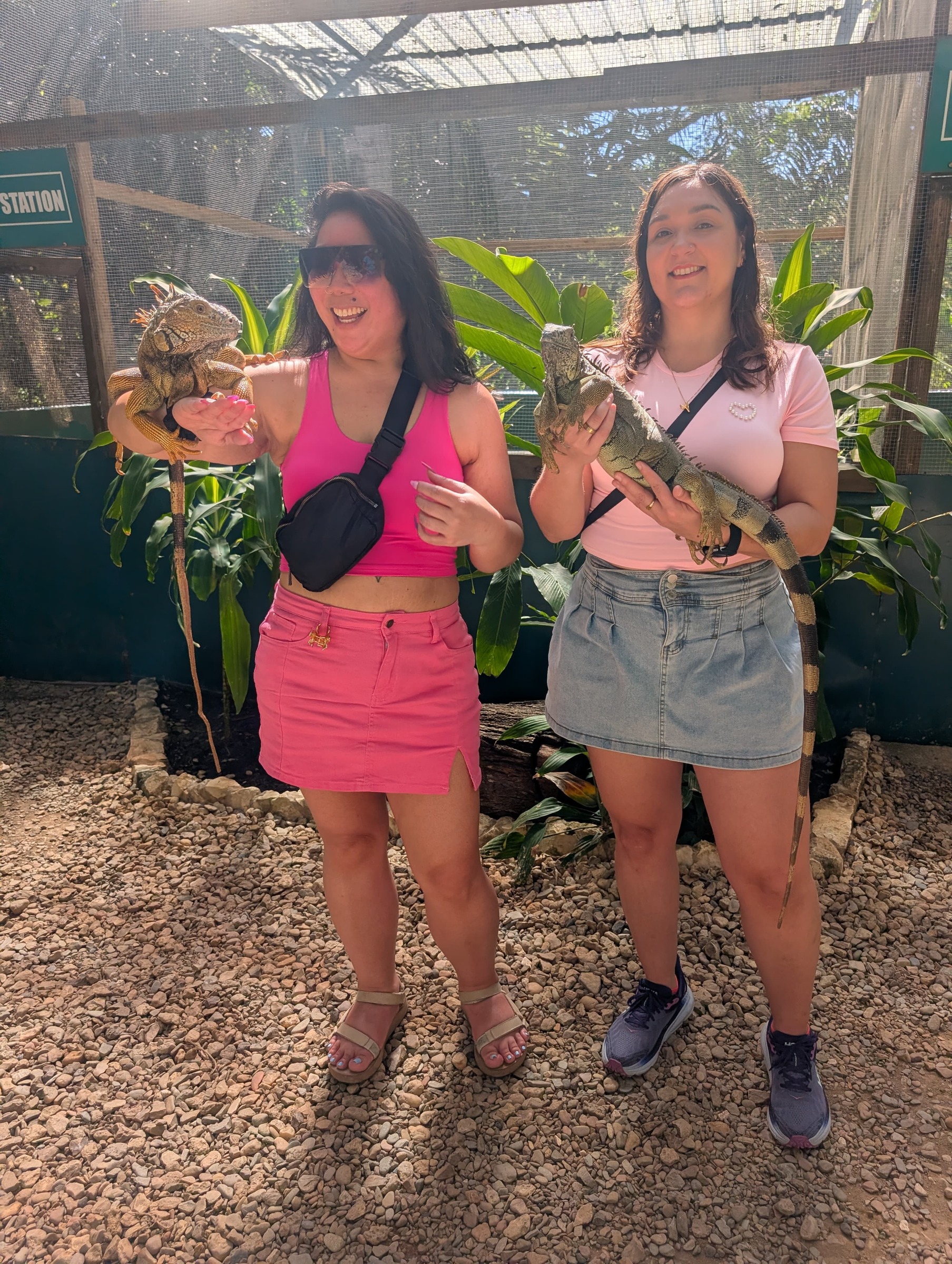 Marie and a fellow traveler holding iguanas during an outing